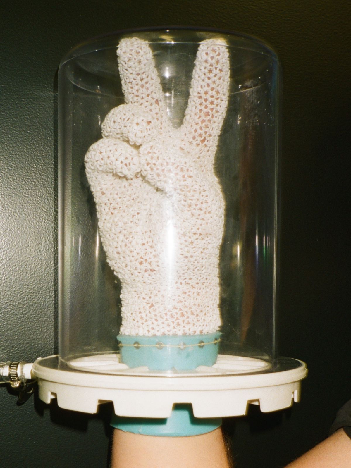 A Starsuit glove giving a peace sign inside a vacuum chamber